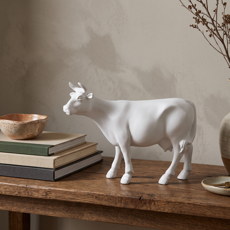 Vache en résine Kuhtag — Blanche H15 cm — en situation (mise en scène numérique)