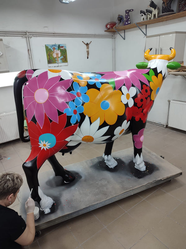 Peintre de l’atelier détaillant les fleurs d’une vache Kuhtag