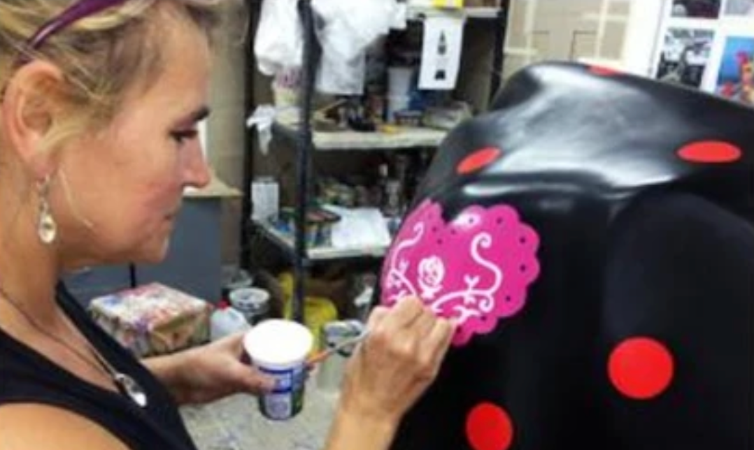 Artiste peignant des fleurs à la main sur une vache Kuhtag