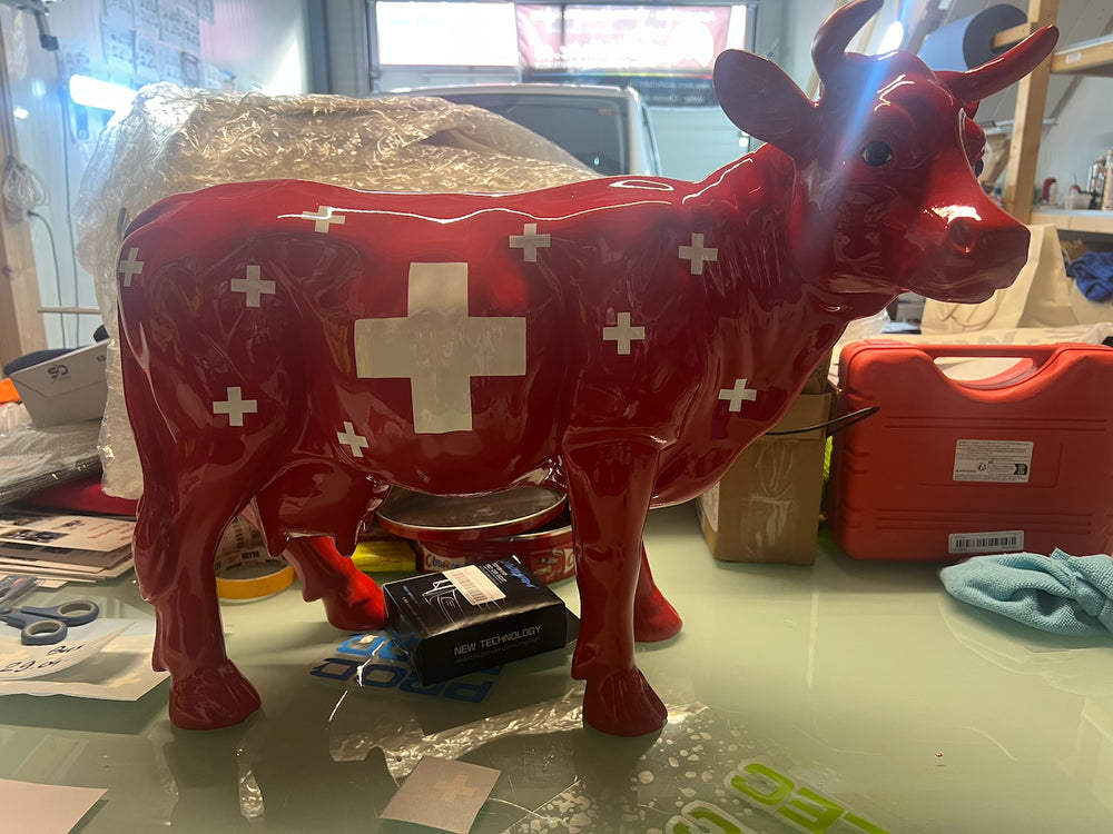 Vache Kuhtag rouge couverte de croix suisses