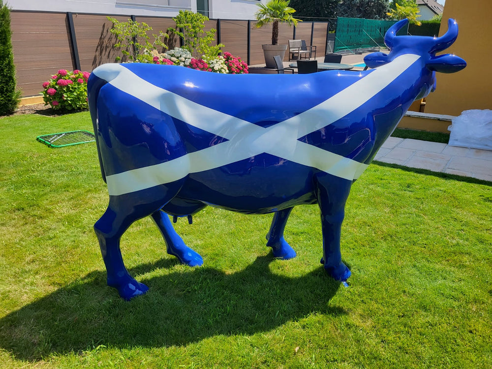 Vache Kuhtag au drapeau écossais dans un jardin