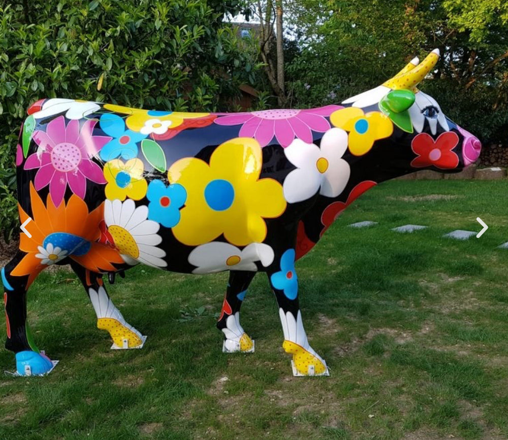 Vache Kuhtag à grosses fleurs dans un jardin
