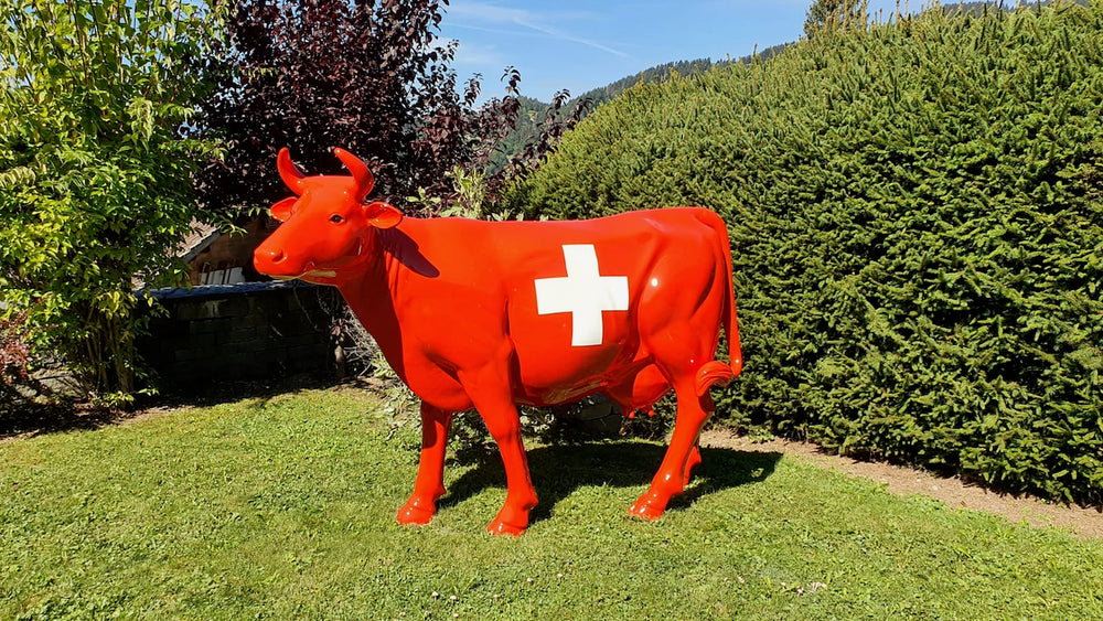Vache Kuhtag à croix suisse dans un jardin