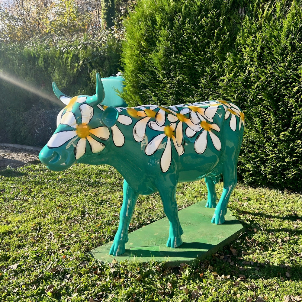 Vache Kuhtag verte à marguerites dans un jardin