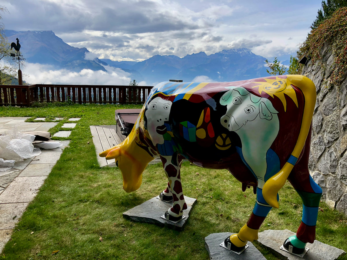 Vache Kuhtag style Picasso dans un jardin face aux Alpes