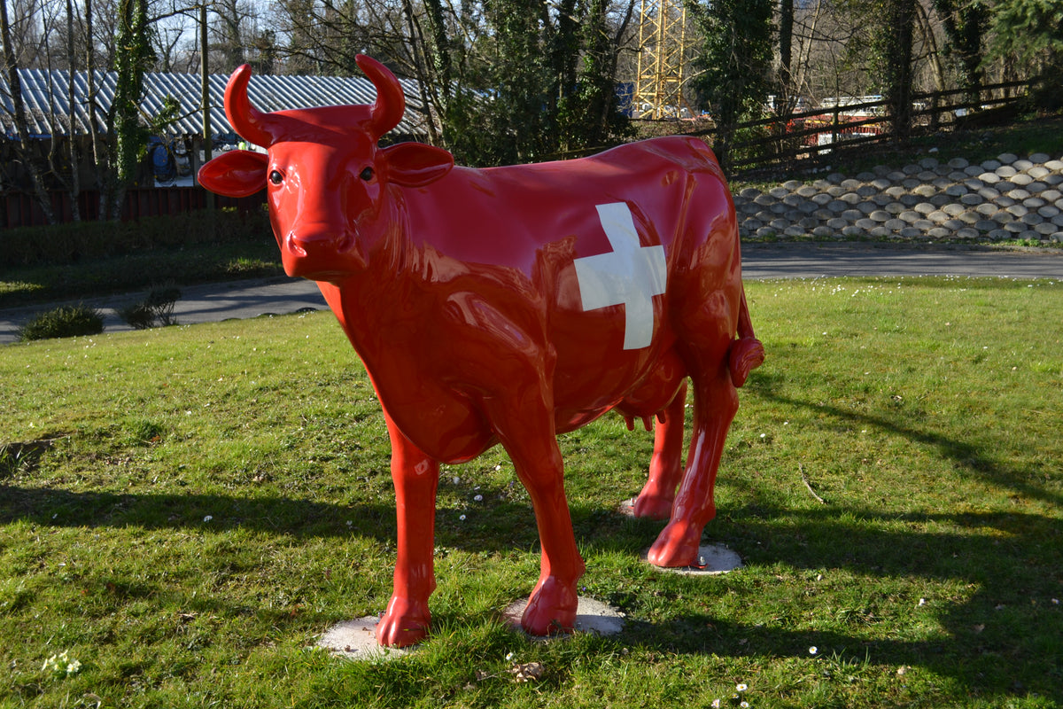 Vache Kuhtag rouge à croix suisse installée sur la pelouse d’un campus d’entreprise