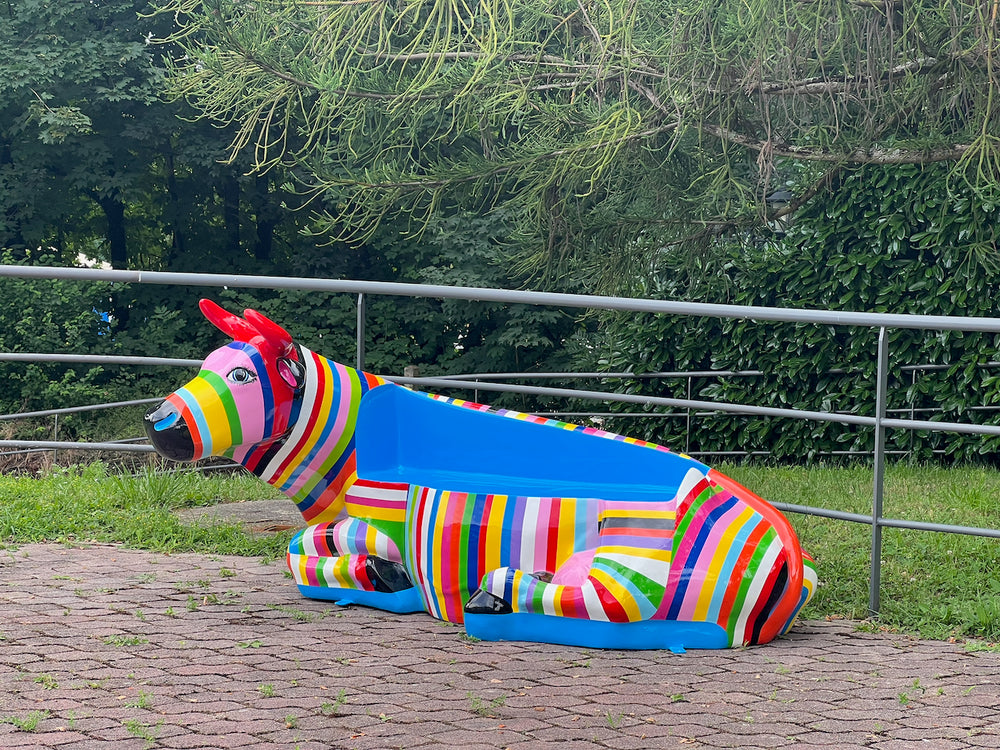 Vache-banc Kuhtag multicolore installée devant un bâtiment d’entreprise