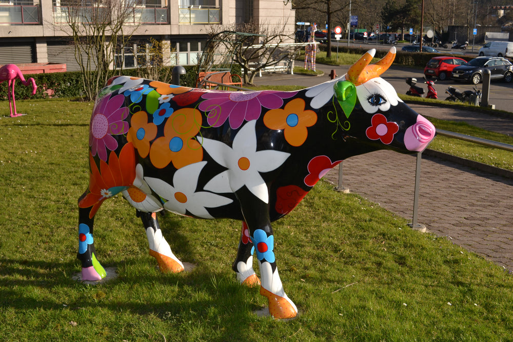 Vache Kuhtag à fleurs sur la pelouse d’un campus
