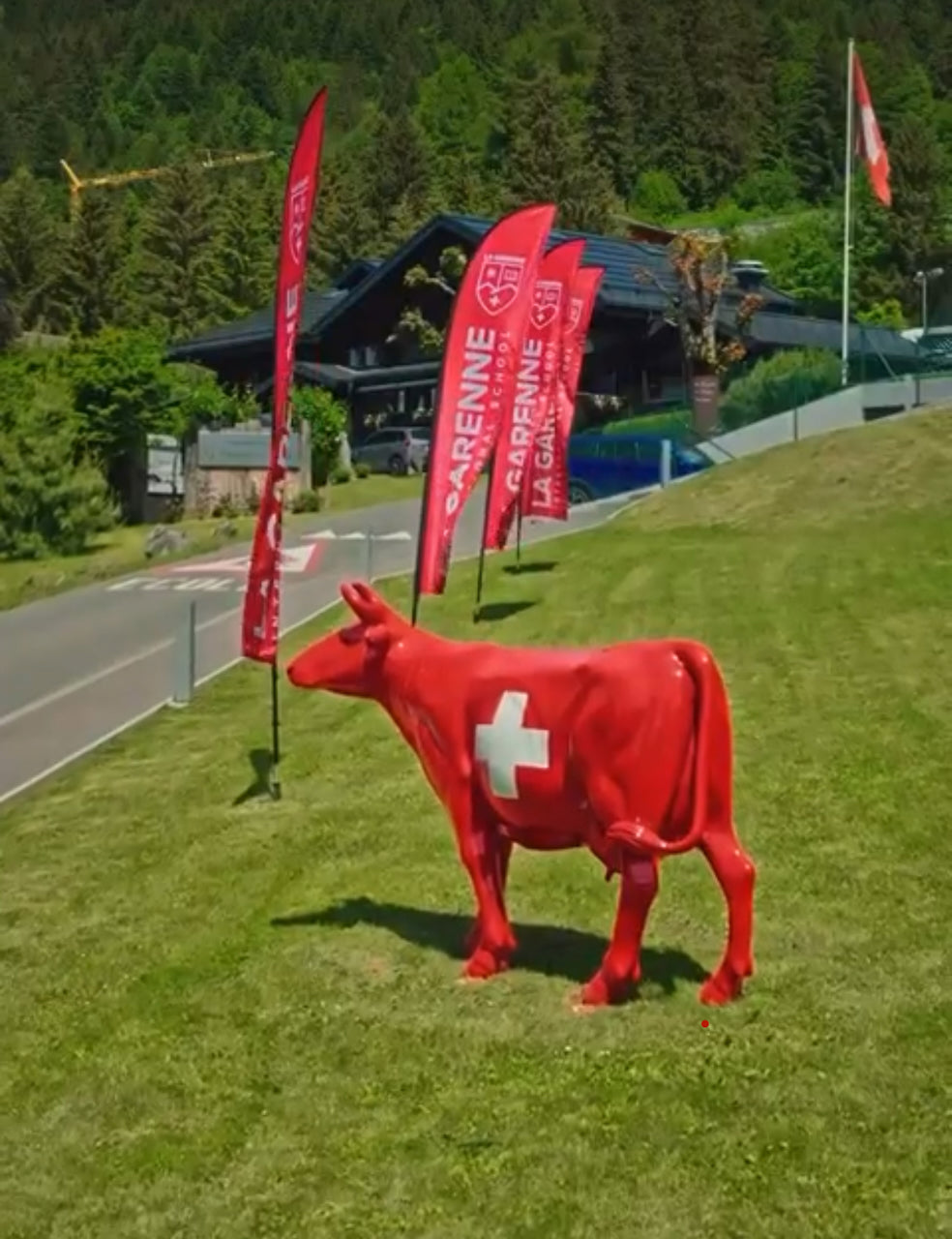 Vache Kuhtag à croix suisse devant des drapeaux lors d’un événement